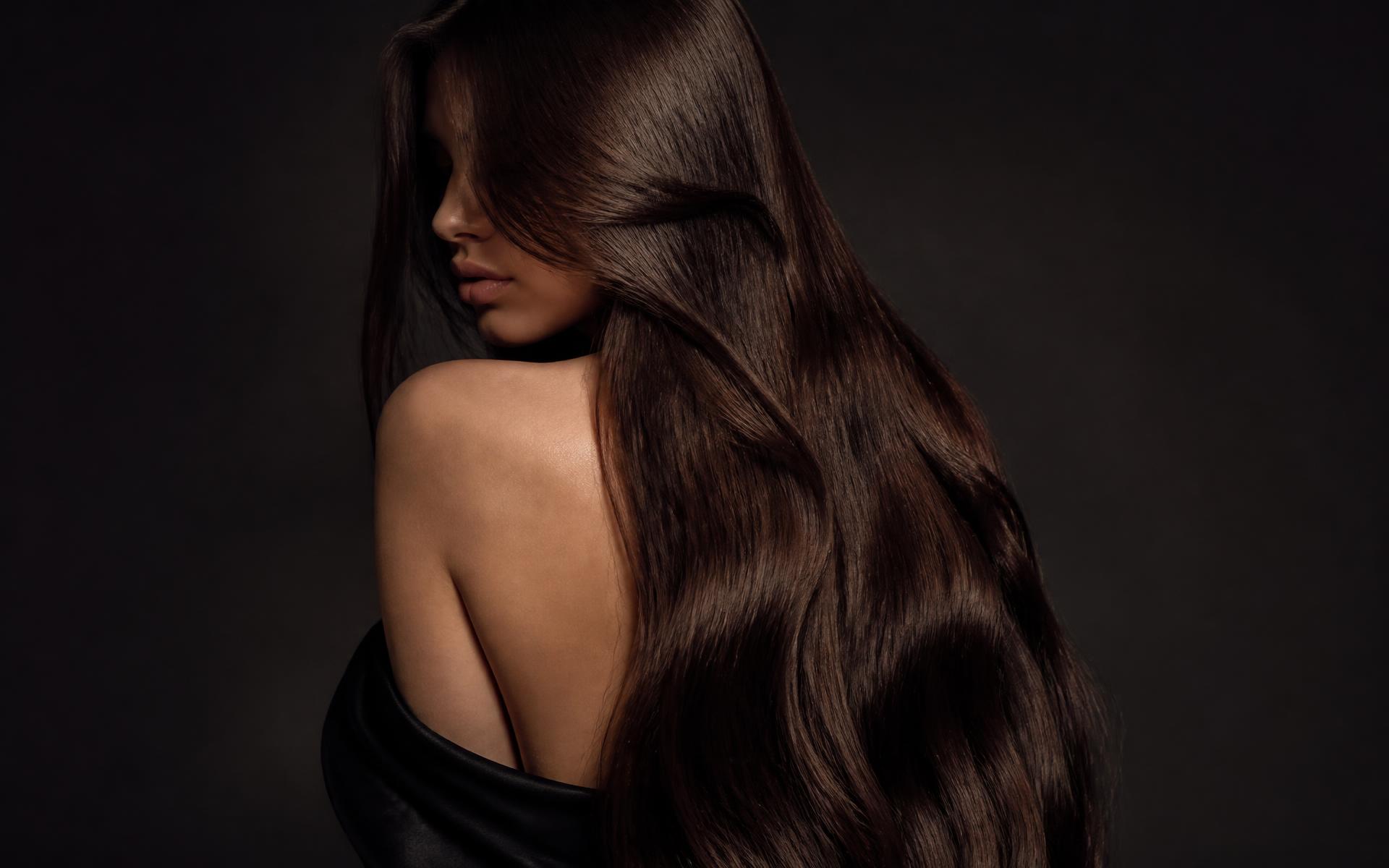 Long, glossy dark hair styled in soft waves